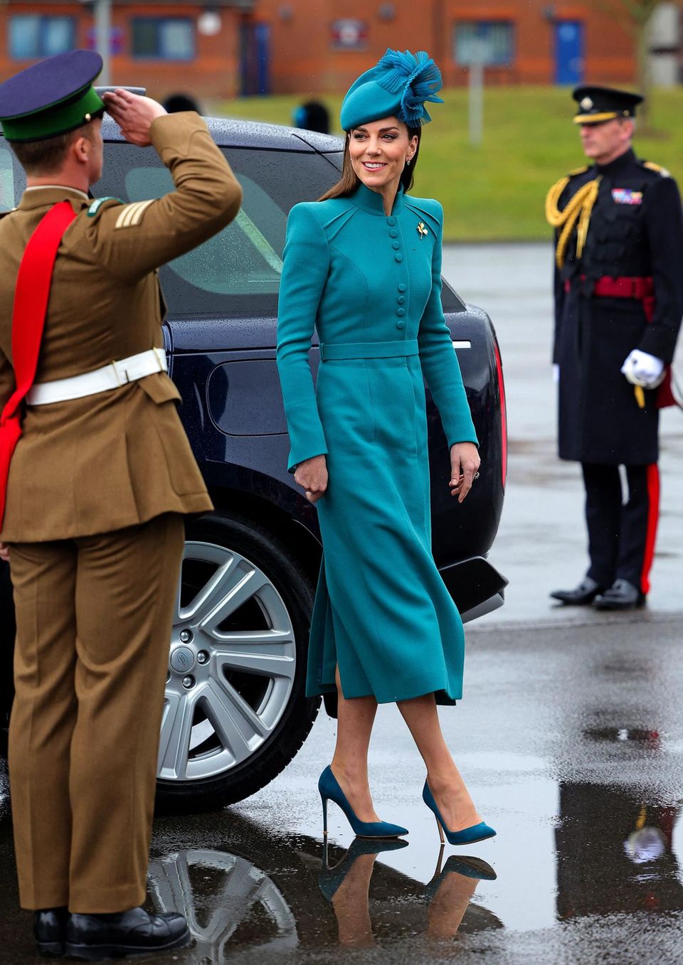 Kate beams away the rain in Aldershot in Catherine Walker's turquoise coat dress. 