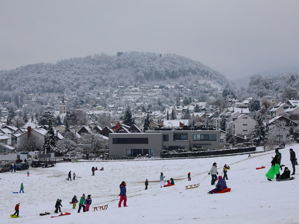 Many people with sleds or bobsleighs on a white slope