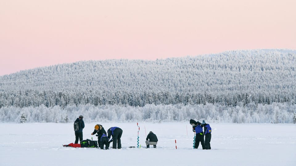 People fishing on a frozen lake. 