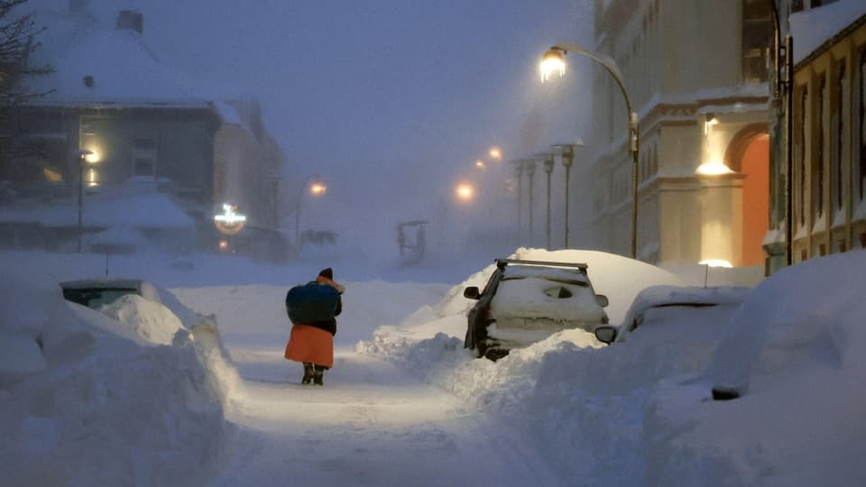 A woman runs on a snowy street. 