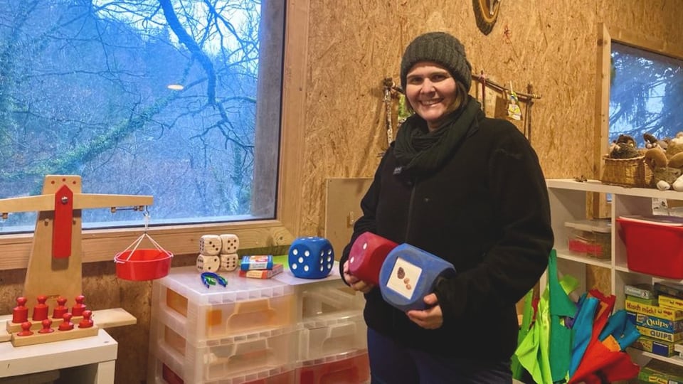 Kindergarten teacher Claudia Hartmann stands in the zoo kindergarten and holds cubes in her hands.