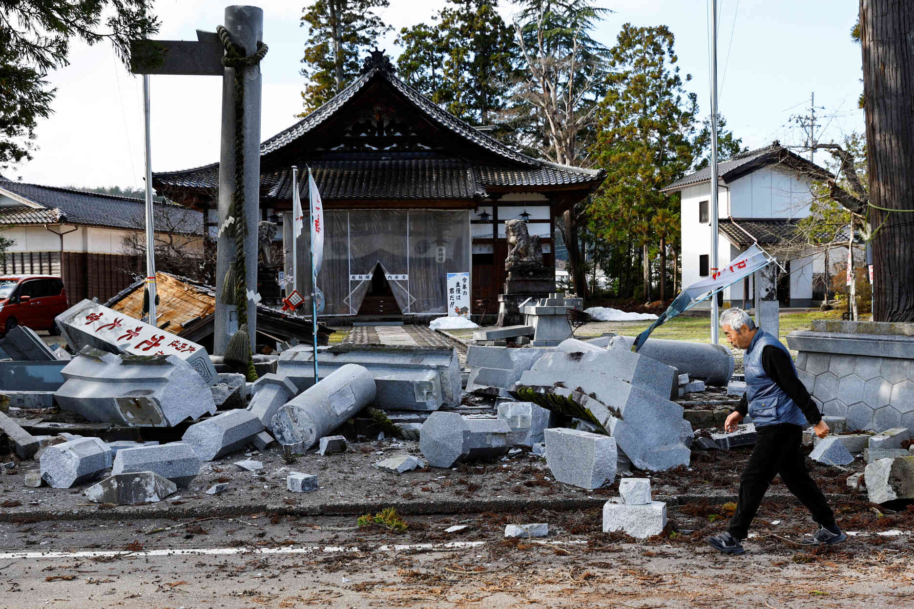 A man walks past a damaged shrine in Ujima, Ishikawa Prefecture, Japan, January 2, 2024.