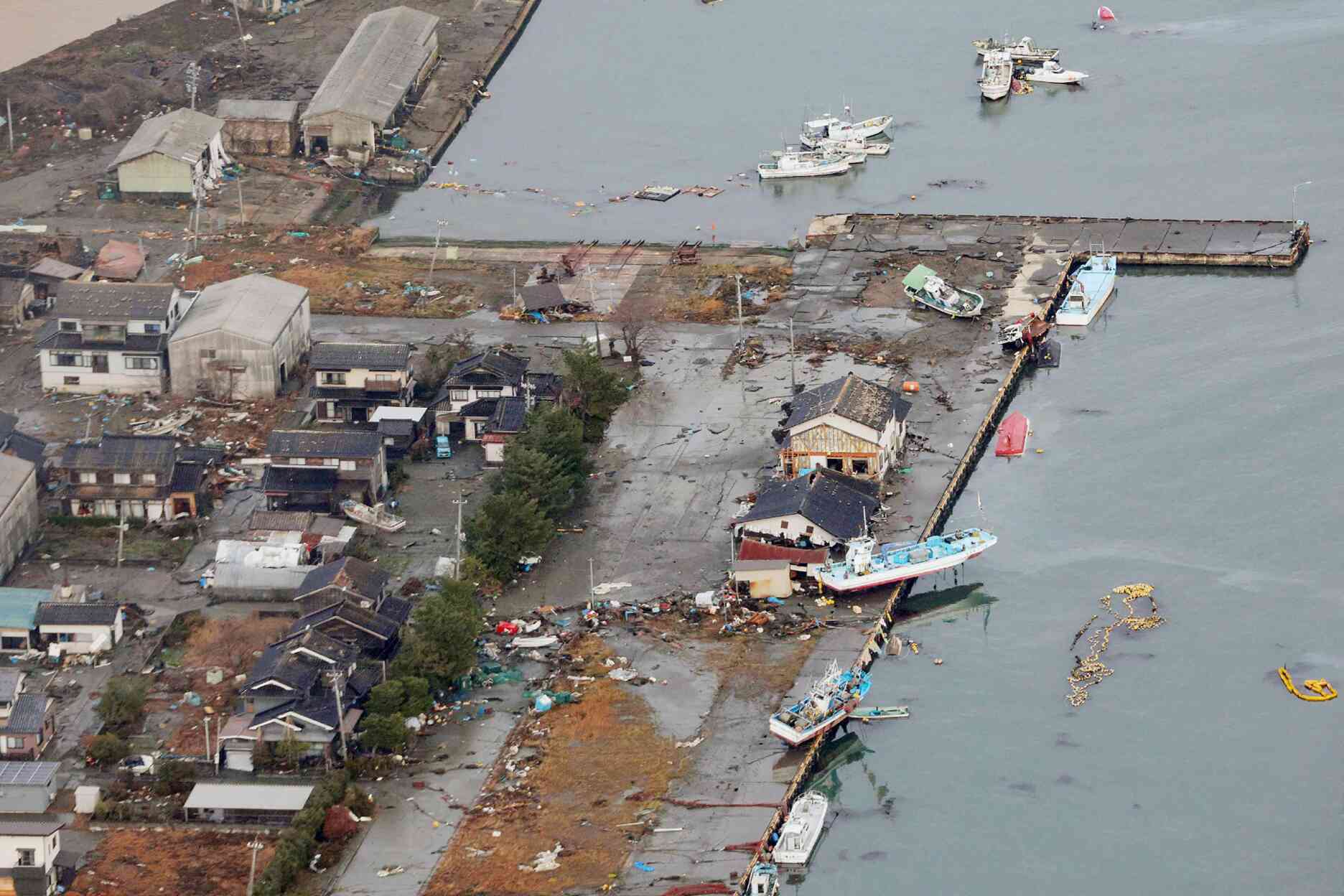 This aerial photo provided by Jiji Press shows capsized boats and others left ashore at the fishing port in Suzu city, Ishikawa Prefecture, Japan, January 2, 2024.
