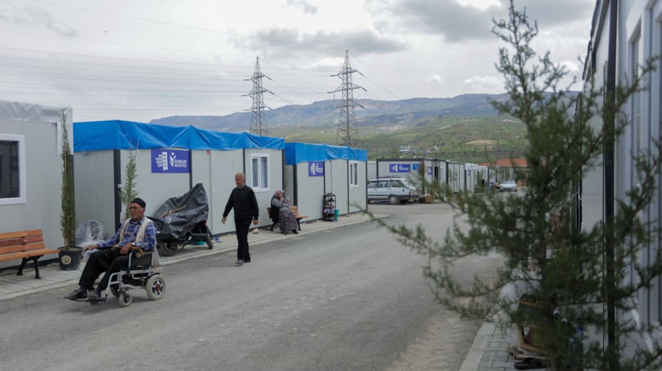 Container village, some containers are covered with plastic sheets.