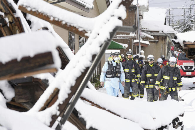 Firefighters search, under the snow, houses that fell in the Japanese city of Suzu during the New Year's earthquake, Monday January 8, 2024. 