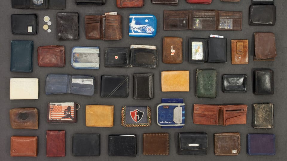 Wallets and purses of different colors, sizes and materials arranged in rows.