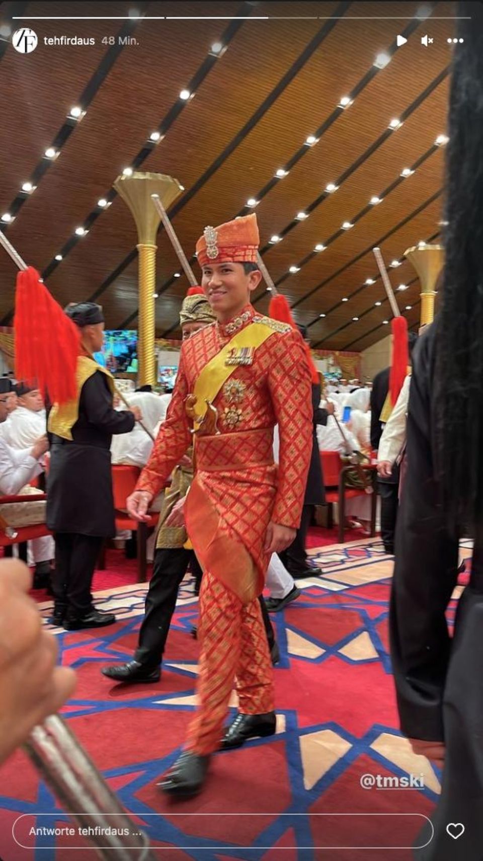 The happy groom is beaming from ear to ear and can be seen in the traditional red wedding robe. 