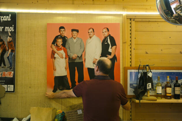 Lionel Rittaud replaces an old family photo displayed in the butcher's shop, in Fourneaux (Savoie), on September 28, 2023.