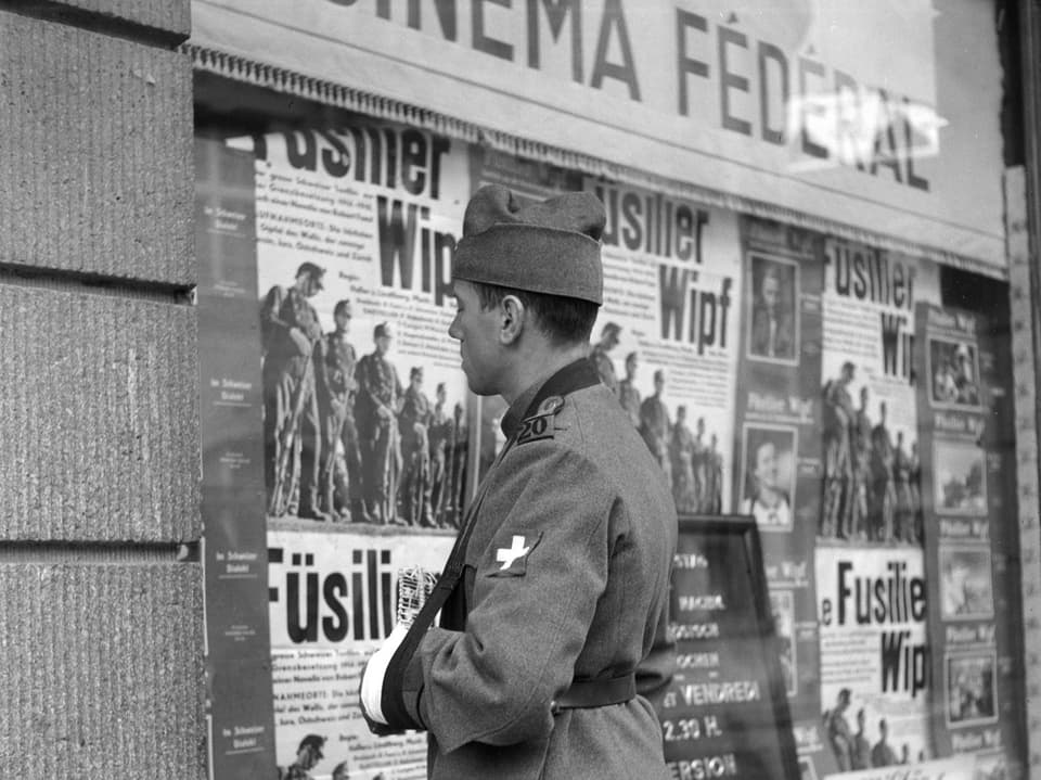 An injured Swiss Army soldier in front of the Cinema Fédéral, which was showing the feature film “Füsilier Wipf”.