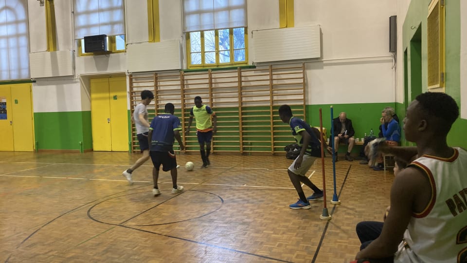 Young men play football in a gym