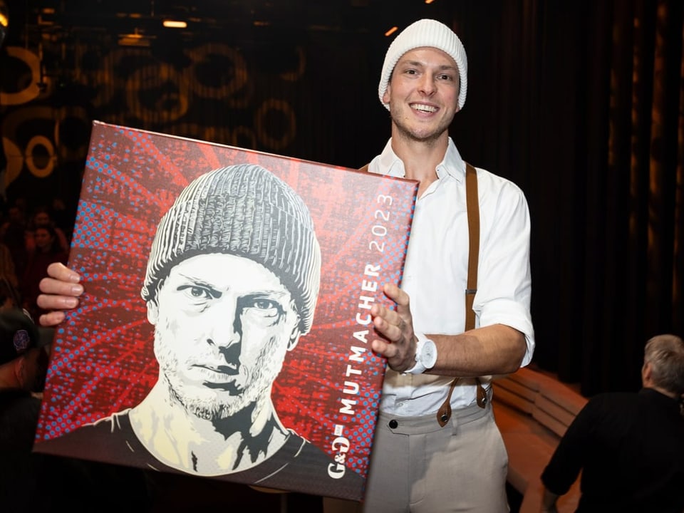 Kevin Lötscher holds his picture as a prize for the “Encourager of the Year”.