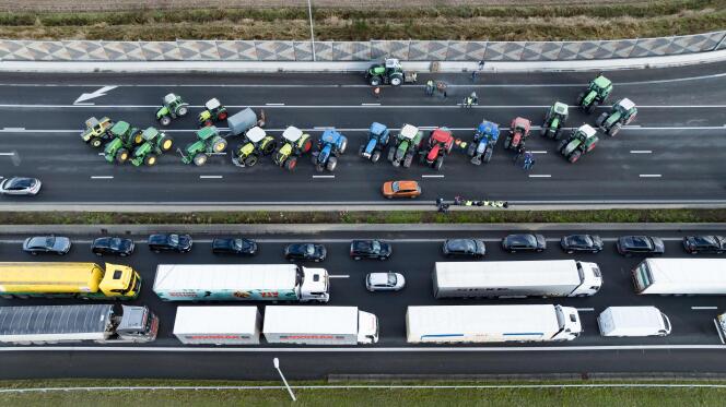 Aerial view showing a traffic jam on a Belgian highway, alongside a blockade organized by farmers.