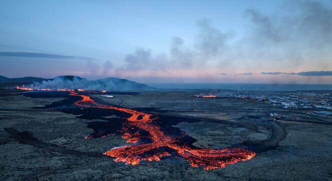 Lava explosions and plumes of smoke are visible near residential buildings in the town of Grindavik (southwest Iceland) on January 14, 2024. 