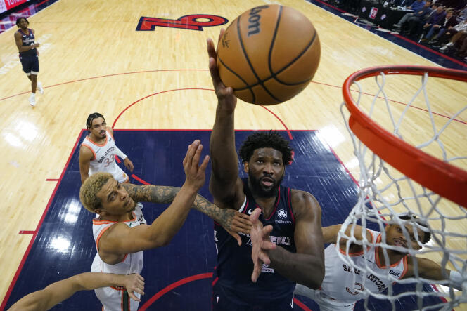 Philadelphia 76ers center Joel Embiid attempts a shot between Jeremy Sochan, left, and Keldon Johnson of the San Antonio Spurs during the second half of an NBA basketball game, Jan. 22, 2024, in Philadelphia. 