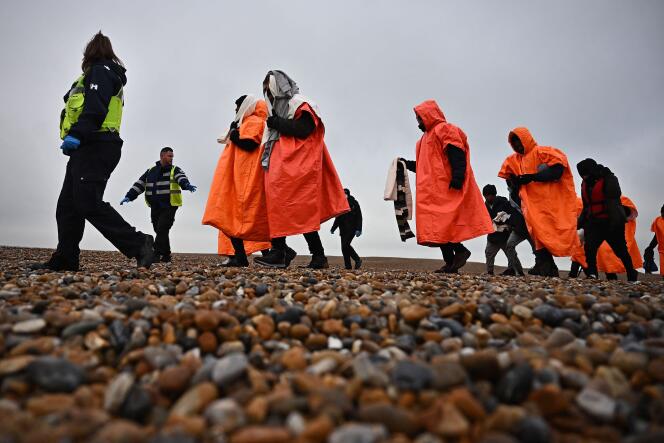Migrants picked up at sea while trying to cross the English Channel are escorted to the shore of Dungeness, on the southeast coast of England, December 9, 2022.