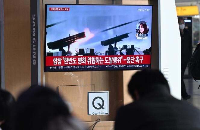 People watch a television screen broadcasting a news bulletin that shows artillery fire from North Korea, at a train station in Seoul, January 5, 2024.