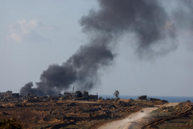 Smoke rises as Israeli military vehicles move through central Gaza, January 5, 2024. 