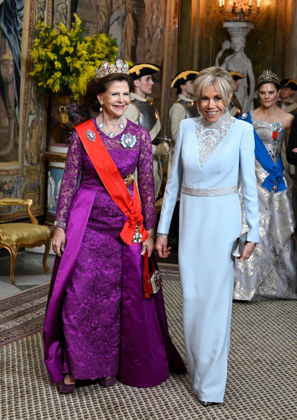 Queen Silvia and Brigitte Macron are in a good mood.