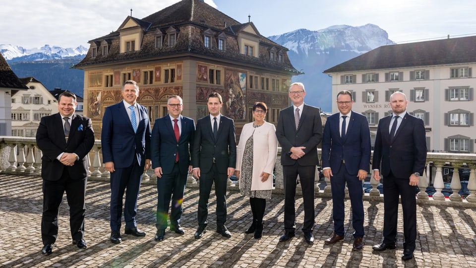 The seven-member Schwyz cantonal government is standing outside in the snow.