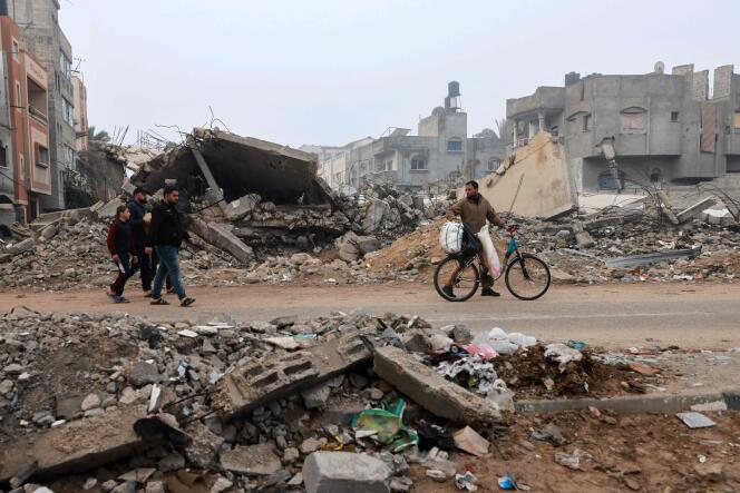 Men walk on a street ravaged by Israeli bombings in Rafah, in the southern Gaza Strip, February 9, 2024.