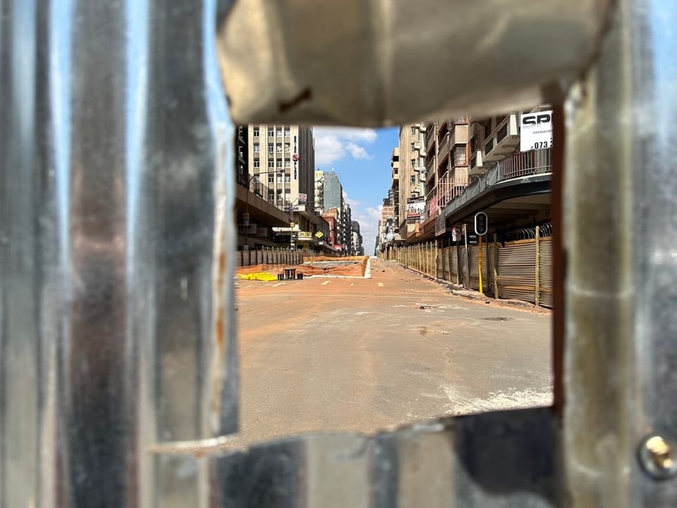 View through opening in fence onto section of road