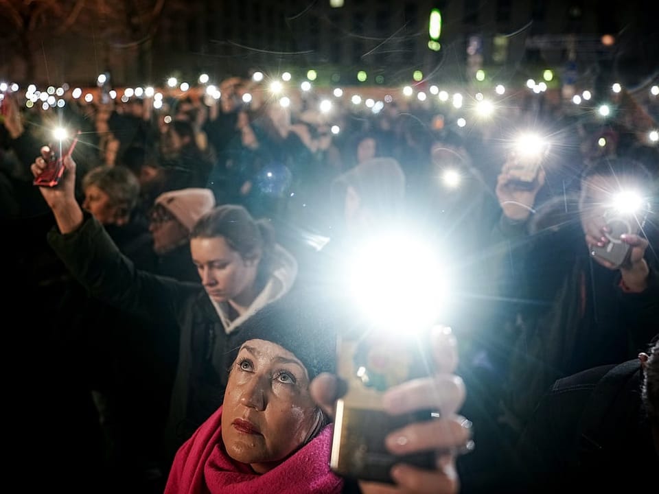 Demonstrators hold up their smartphone lights in front of the Russian Embassy after the death of Alexei Navalny.