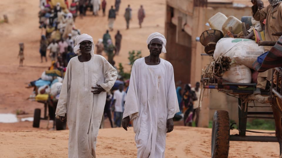 Sudanese men cross the Sudan/Chad border.