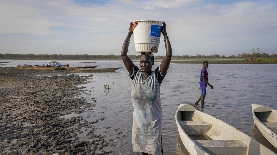 A woman carries water from a swamp on her head in South Sudan.