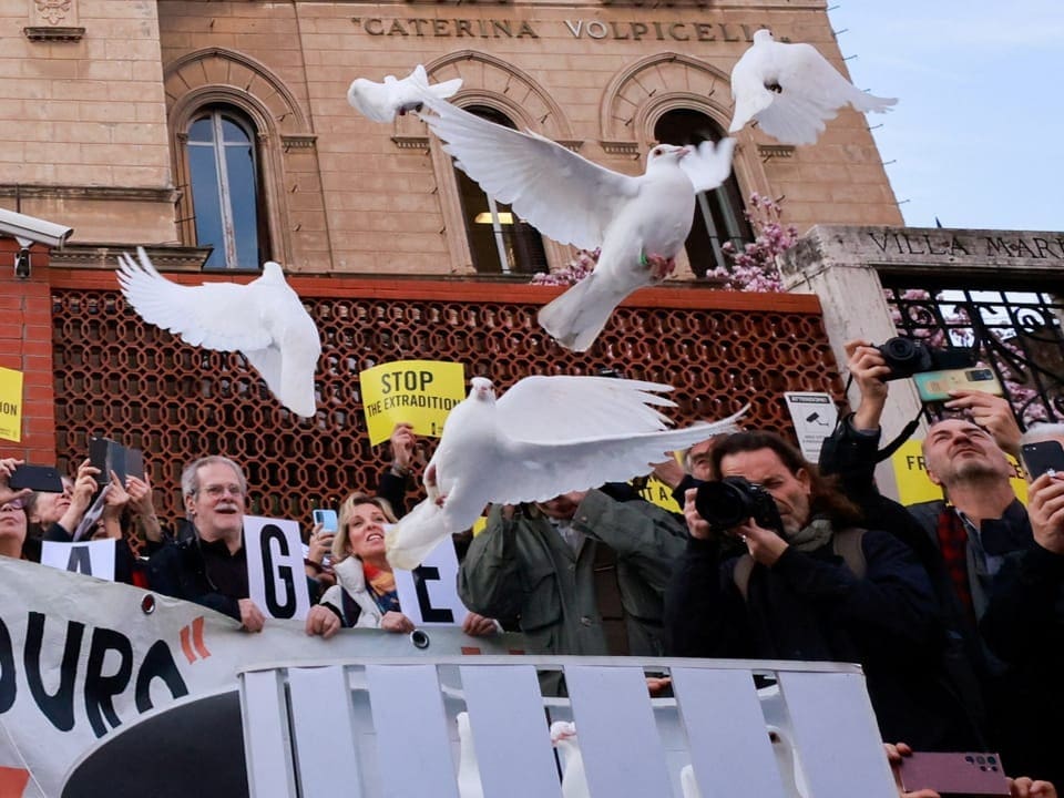 Demonstrators let white doves fly.