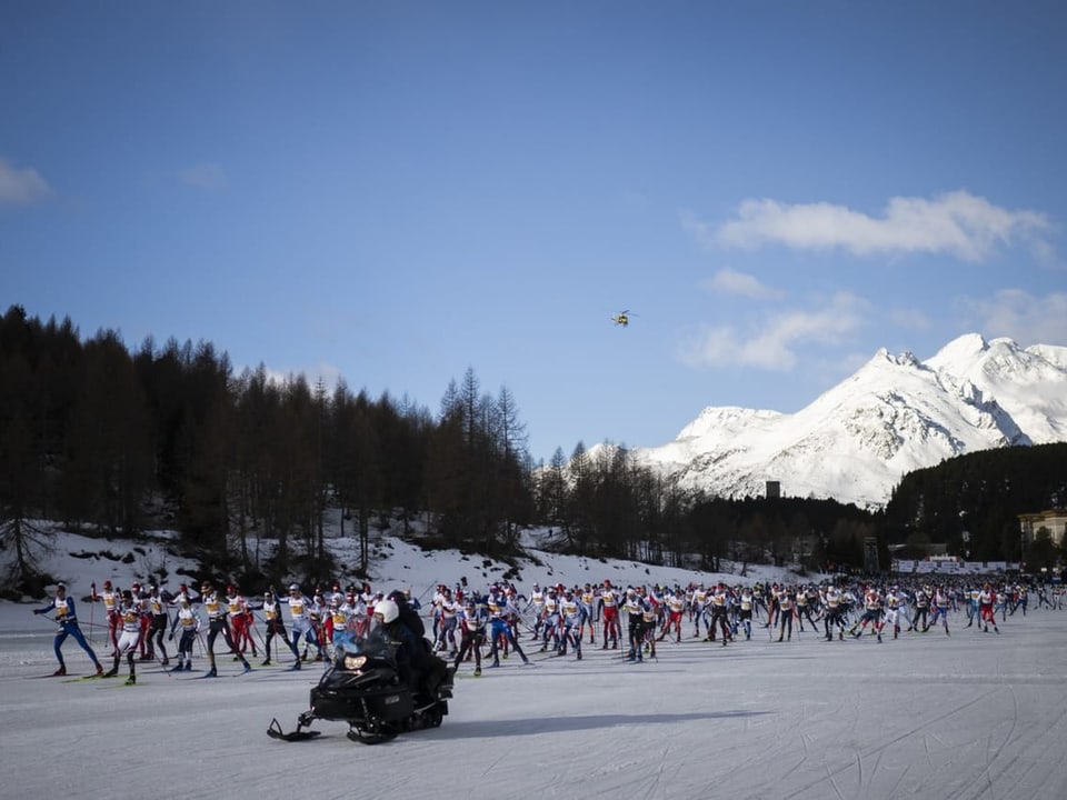 Runners at the Engadin Ski Marathon.  In the background the blue sky and white mountains.