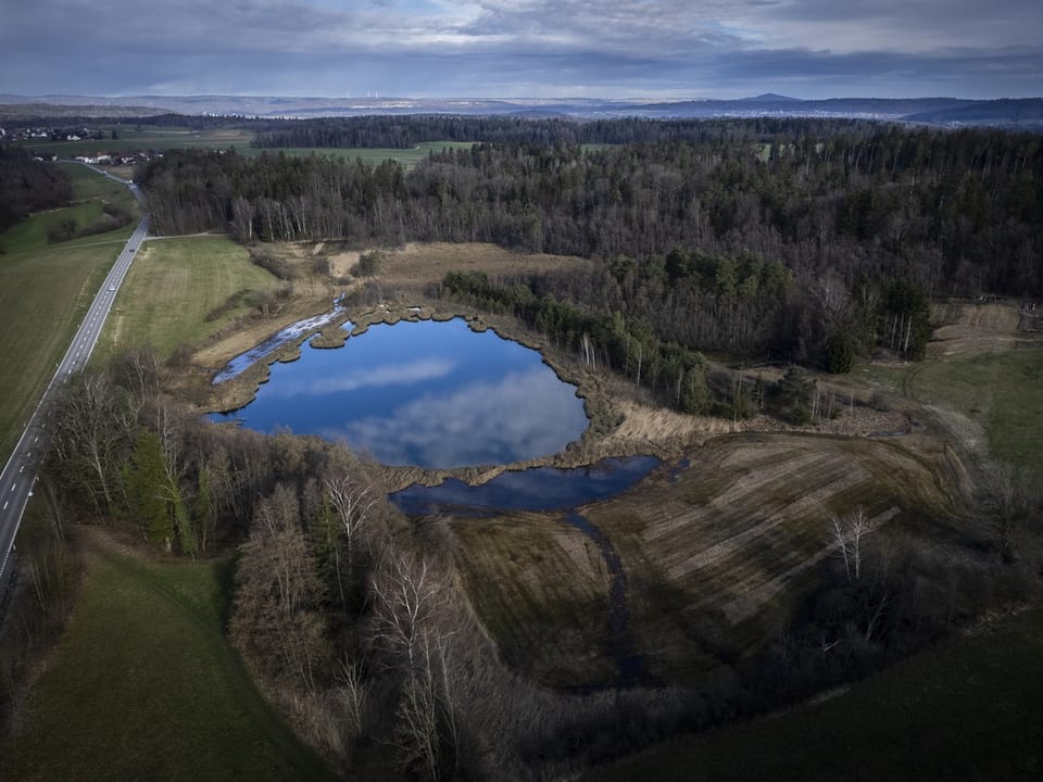 Aerial photo: Small lake next to a road 