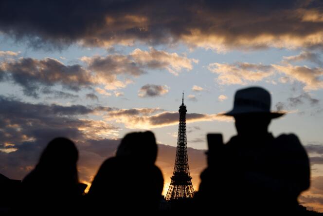 Tourists take a photo of the Eiffel Tower in Paris on February 12, 2024.