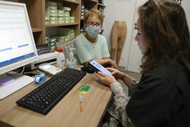 A woman speaks to a pharmacy employee before receiving a dose of vaccine against Covid-19, in Ajaccio, October 5, 2023.
