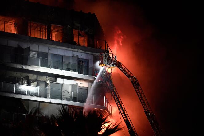 Firefighters intervene on the apartment building which caught fire on February 22, 2024 in Valencia (Spain).