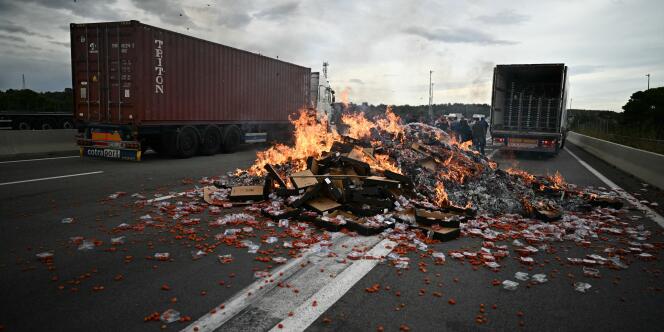 Boxes of tomatoes burn on the highway at the Boulou toll booth, near the Spanish border, in the south of France, October 19, 2023.