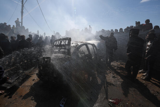 Palestinians gather around a car hit by an Israeli bombing, in Rafah, in the south of the Gaza Strip, February 4, 2024.