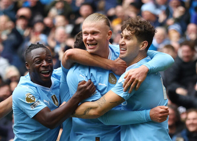 Erling Haaland (center) celebrates his first goal against Everton with Jérémy Doku (left) and John Stones (right), on February 10, 2024, in Manchester (United Kingdom). 