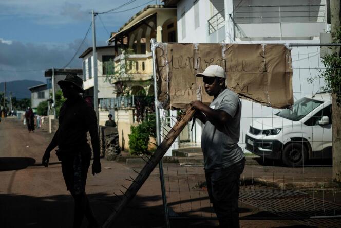A member of the Forces Vives collective stands on a road block, in Passamainty, on February 15, 2024, to protest against living conditions and insecurity in Mayotte.