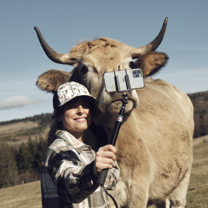 Pauline Garcia, breeder in Cantal, photographs herself with one of her cows, February 14, 2024.