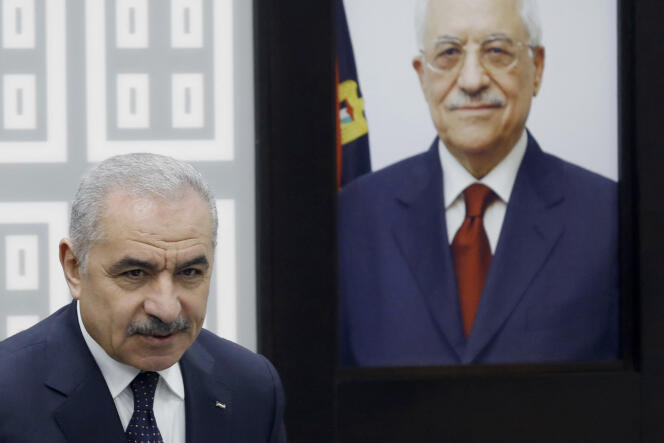 Palestinian Prime Minister Mohammed Shtayyeh stands next to a portrait of Palestinian Authority President Mahmoud Abbas during a cabinet meeting during which he announced the resignation of his government in Ramallah on February 26 2024.