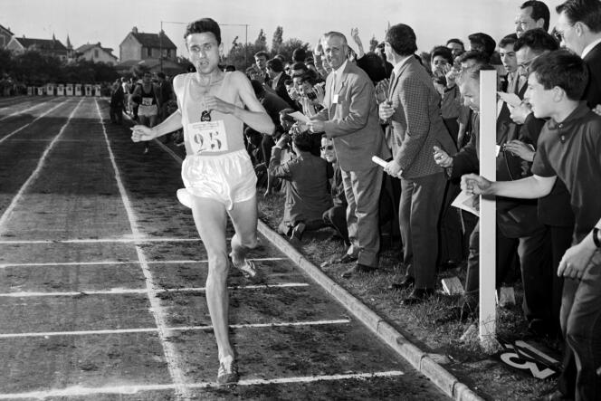 Michel Jazy, encouraged by the crowd, crossed the finish line during a meeting in Melun, June 24, 1965.