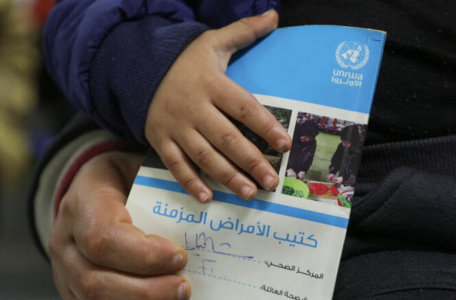 A child holds a booklet as he waits inside a health center of the United Nations agency for Palestinian refugees (UNRWA) in the Palestinian refugee camp of Shatila, in the suburbs from Beirut, Lebanon, on January 30, 2024.