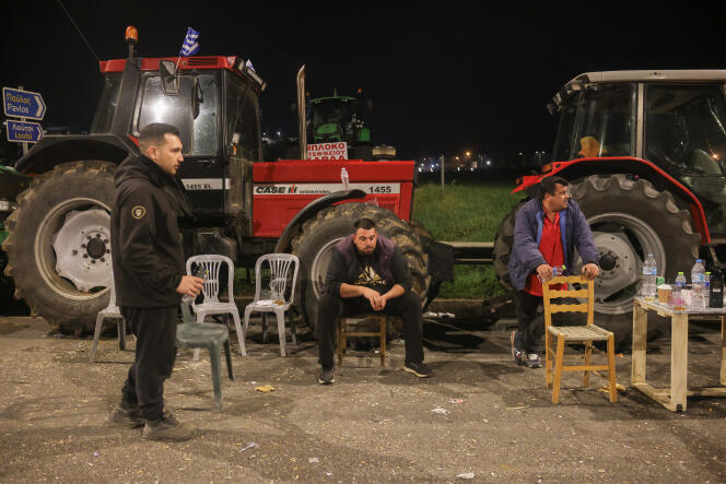 Farmers rest next to tractors on the national highway, a day before heading to Athens, near Kastro, Greece, February 19, 2024.