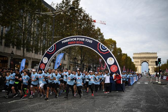 Runners take the start of a 5-kilometer race along the Champs-Elysées, during the J-1000 Paris 2024 – Marathon for all, in Paris, October 31, 2021. 