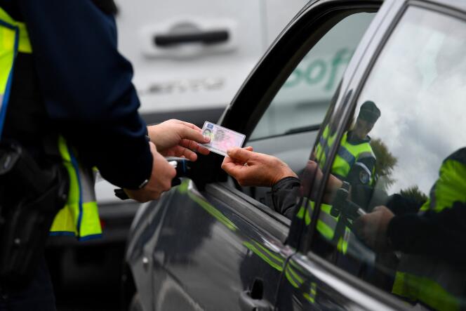 A gendarme checks the driving license of a motorist, in Noyal-Chatillon-sur-Seiche (Ille-et-Vilaine), October 17, 2019.