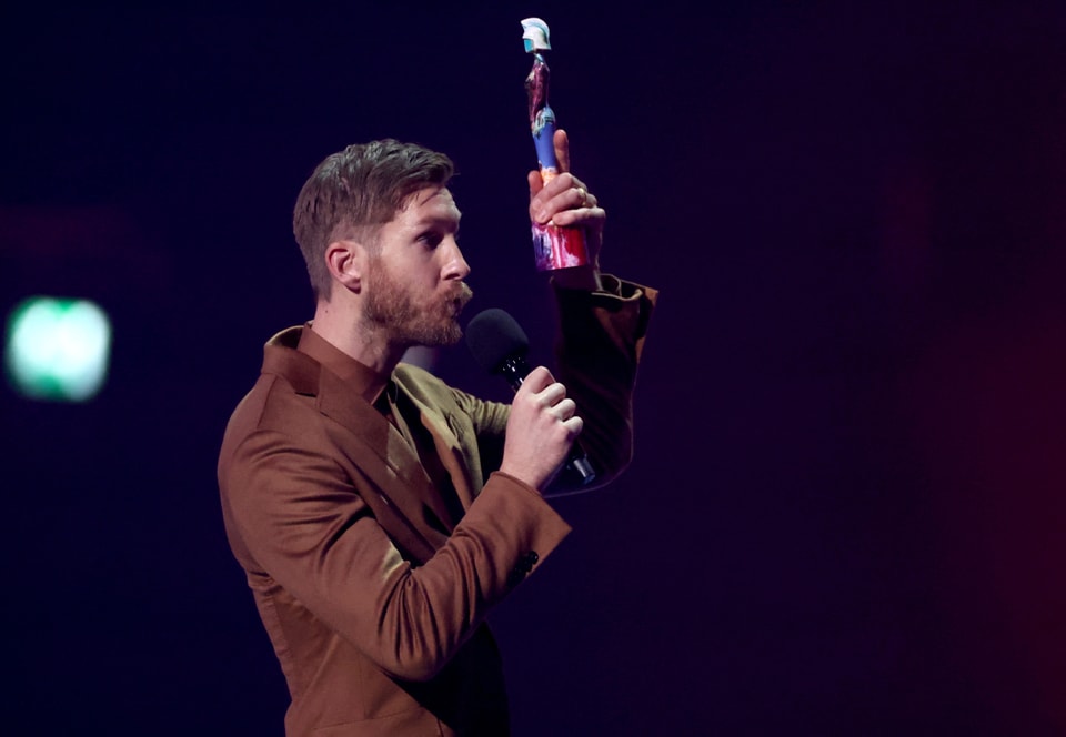 Calvin Harris with a trophy in his hand.