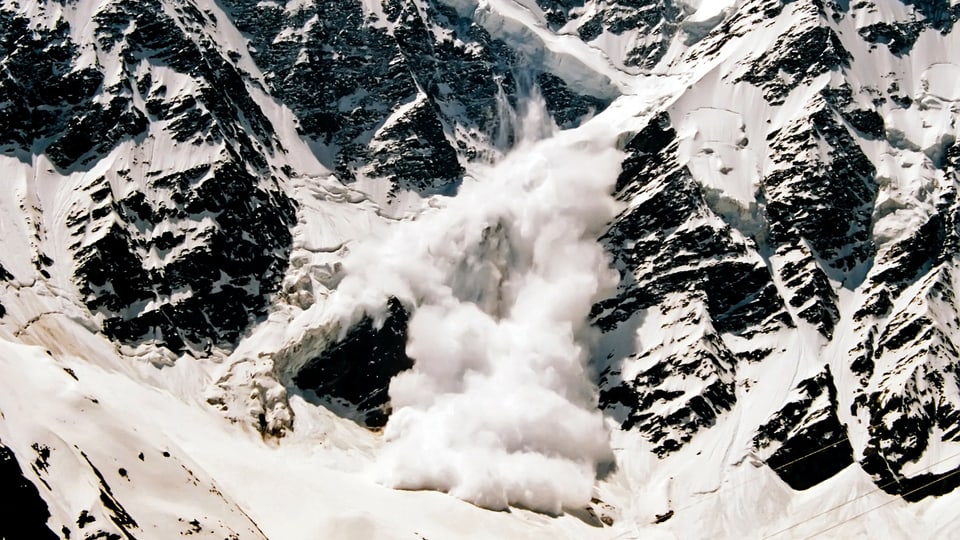 Avalanche goes over a rock face