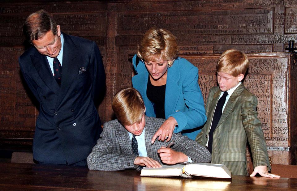 Prince William signs his name in a book on his first day at Eton College on September 6, 1995, watched by dad Charles, mom Diana and brother Harry.