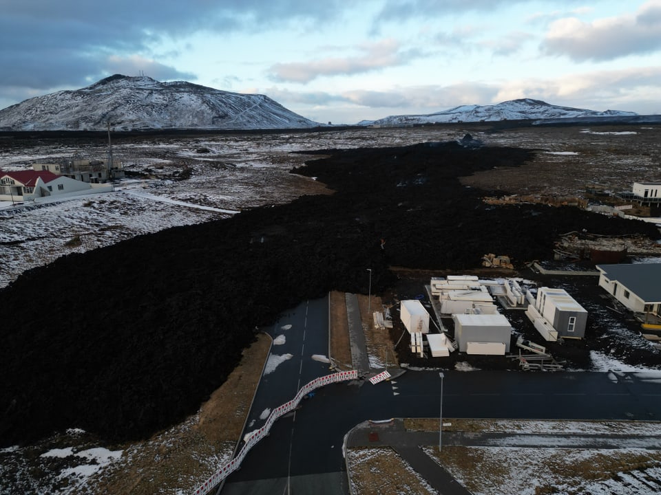 Cooled lava flows reach the first houses in Grindavík.