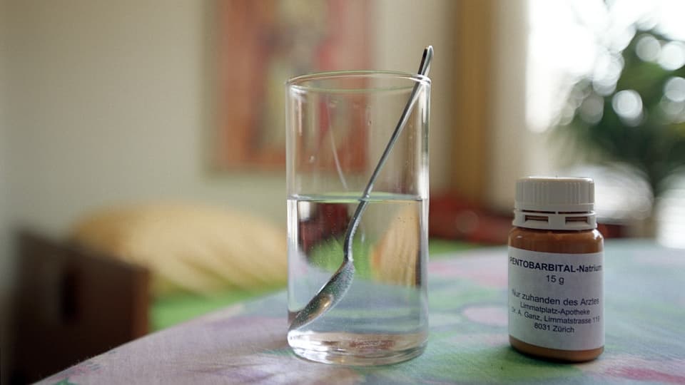 A glass of water with medicine next to it.